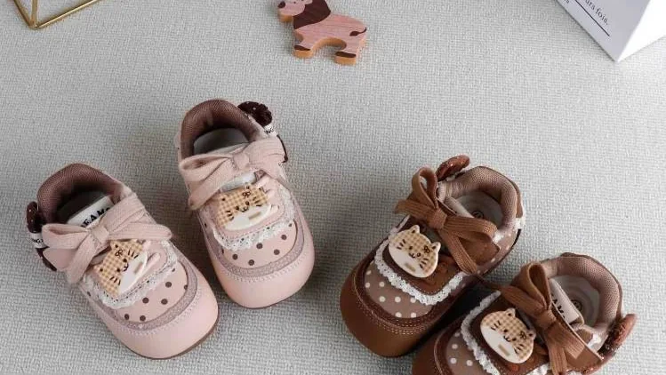 Soft-sole baby shoes with bow and lace details, made in our factory