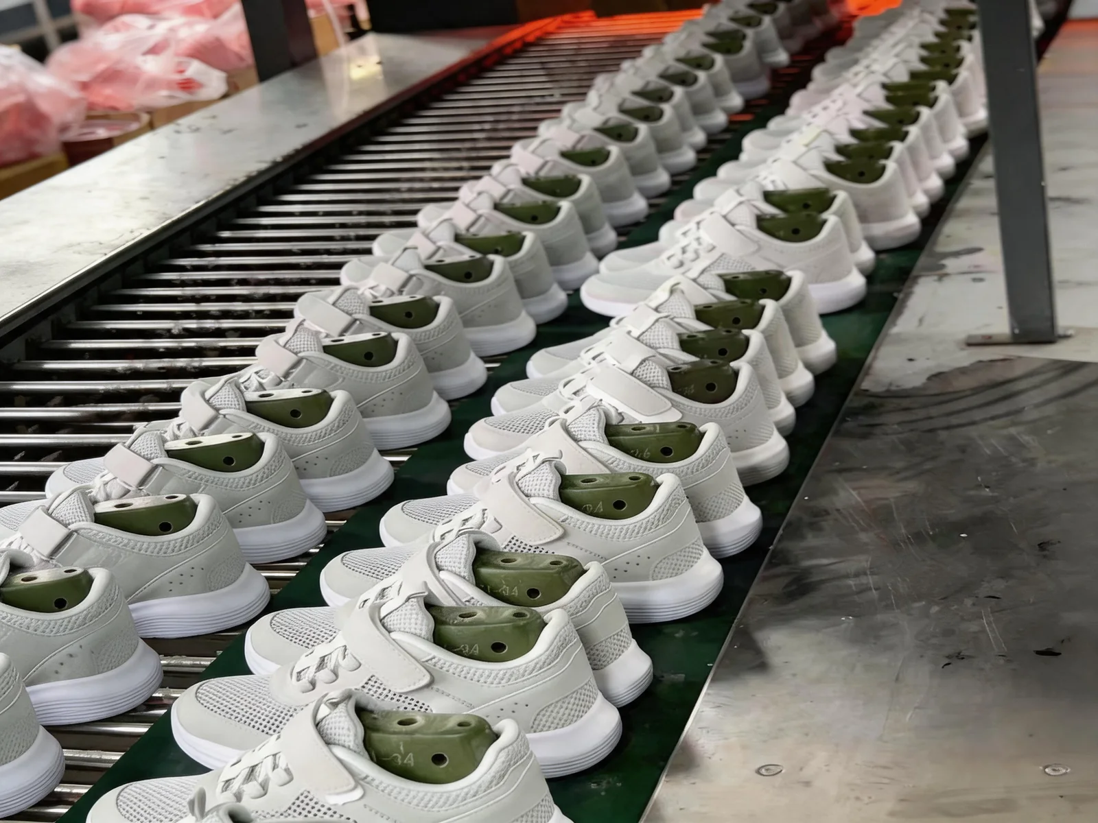White mesh kids sneakers on lasts moving along the production line